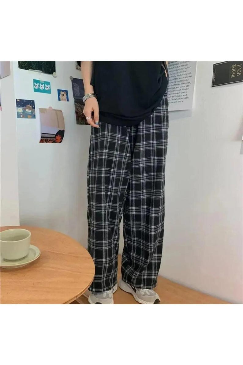 May include: Black and white plaid pants with a wide leg silhouette. The pants are made of a soft, comfortable fabric and have a relaxed fit.