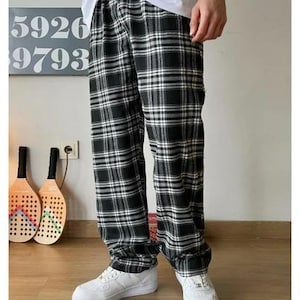May include: Black and white plaid pants with a relaxed fit. The pants have a drawstring waistband and are made of a soft, comfortable fabric.