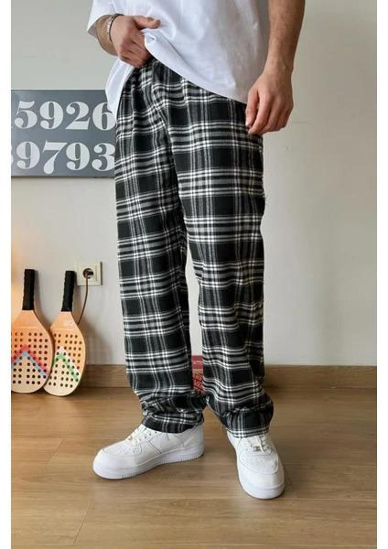 May include: Black and white plaid pants with a relaxed fit. The pants have a drawstring waistband and are made of a soft, comfortable fabric.