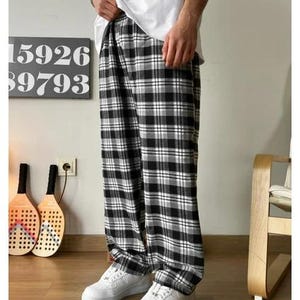 May include: Black and white plaid pants with a relaxed fit. The pants have a wide leg and are made of a soft, comfortable fabric.