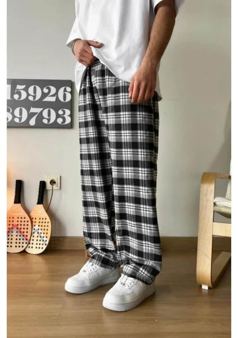 May include: Black and white plaid pants with a relaxed fit. The pants have a wide leg and are made of a soft, comfortable fabric.