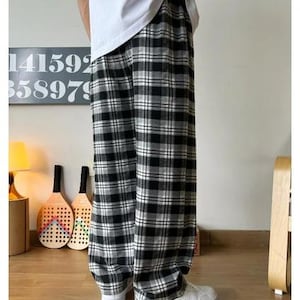 May include: Black and white plaid pants with a relaxed fit. The pants have a wide leg and a comfortable, casual style.