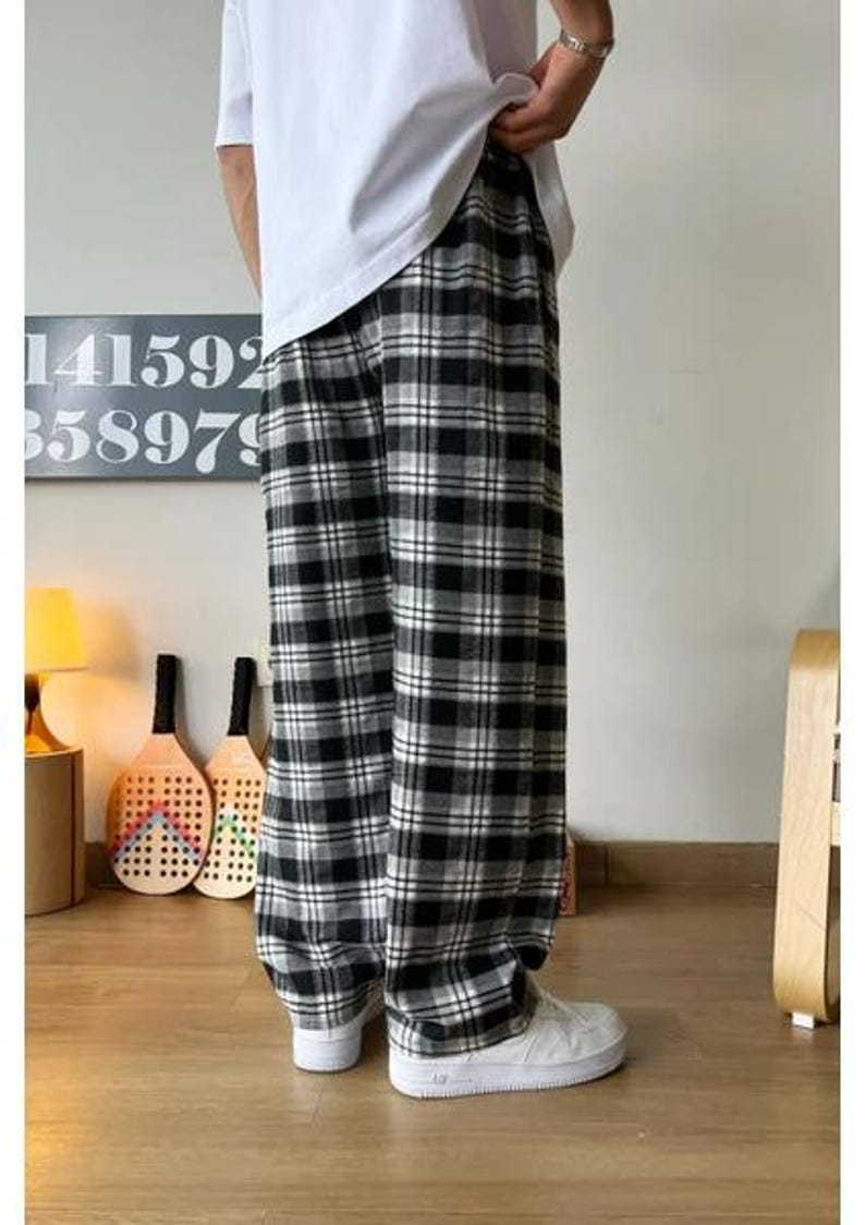 May include: Black and white plaid pants with a relaxed fit. The pants have a wide leg and a comfortable, casual style.