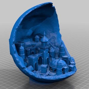 Op de afbeelding: Blauwe, 3D-geprinte miniatuur van een Midden-Oosterse stad, genesteld in een gebarsten, eivormige structuur. Het gedetailleerde model toont gebouwen, koepels en trappen, waardoor een architecturale scène op kleine schaal ontstaat.