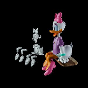 May include: A Daisy Duck figurine with a pink bow, purple top, and orange shoes. The figure is sitting on a wooden base, with several disassembled parts nearby. The background is black.