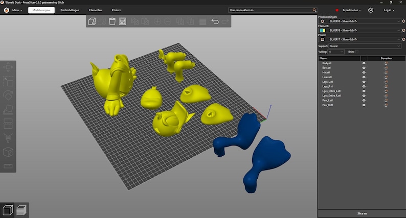 Puede incluir: Un modelo de pato de dibujos animados impreso en 3D, desmontado en varias piezas. Las piezas son amarillas y azules, y est&aacute;n dispuestas sobre una superficie de rejilla gris.