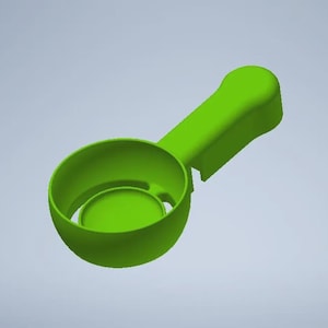 May include: A bright green scoop with a rounded bowl and a handle. The bowl has a circular insert at the bottom. The handle is ergonomic and slightly curved. The object is made of a solid, opaque material.
