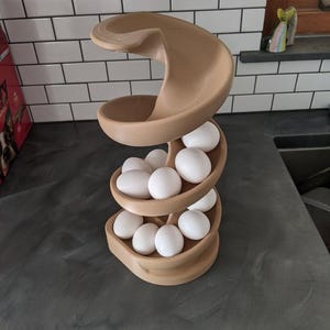 Puede incluir: Un porta huevos de pl&aacute;stico marr&oacute;n en forma de espiral con 12 huevos blancos dentro.