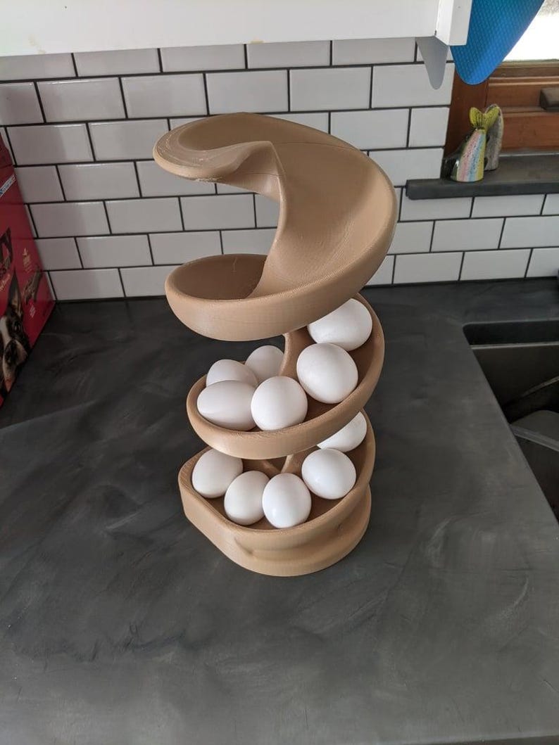 Puede incluir: Un porta huevos de pl&aacute;stico marr&oacute;n en forma de espiral con 12 huevos blancos dentro.