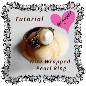 Könnte beinhalten: Eine Anleitung für Anfänger, wie man einen Perlring mit Draht umwickelt. Der Ring ist aus Kupferdraht und einer weißen Perle gefertigt. Der Ring liegt auf einer Muschel.