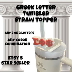 May include: White tumbler with a white straw topper featuring red Greek letters "ΣΦΨ". The tumbler has a black and white Stanley logo. The image is set against a background of white columns.