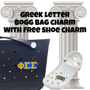 May include: A black and white image of a black  Bogg Bag with a blue and gold Greek letter charm that says "&Phi;&Sigma;&Sigma;".  The bag is sitting on a white surface next to a white clog with the same charm.  The text "Greek Letter Bogg Bag Charm with Free Shoe Charm" is written in black text on a white background.