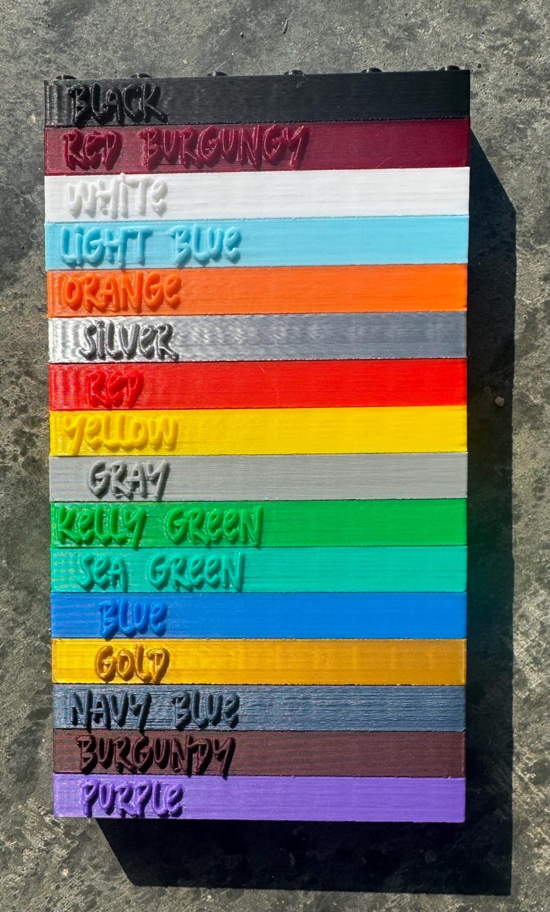 May include: A color chart with 15 different colors, including black, red burgundy, white, light blue, orange, silver, red, yellow, gray, kelly green, sea green, blue, gold, navy blue, burgundy, and purple.