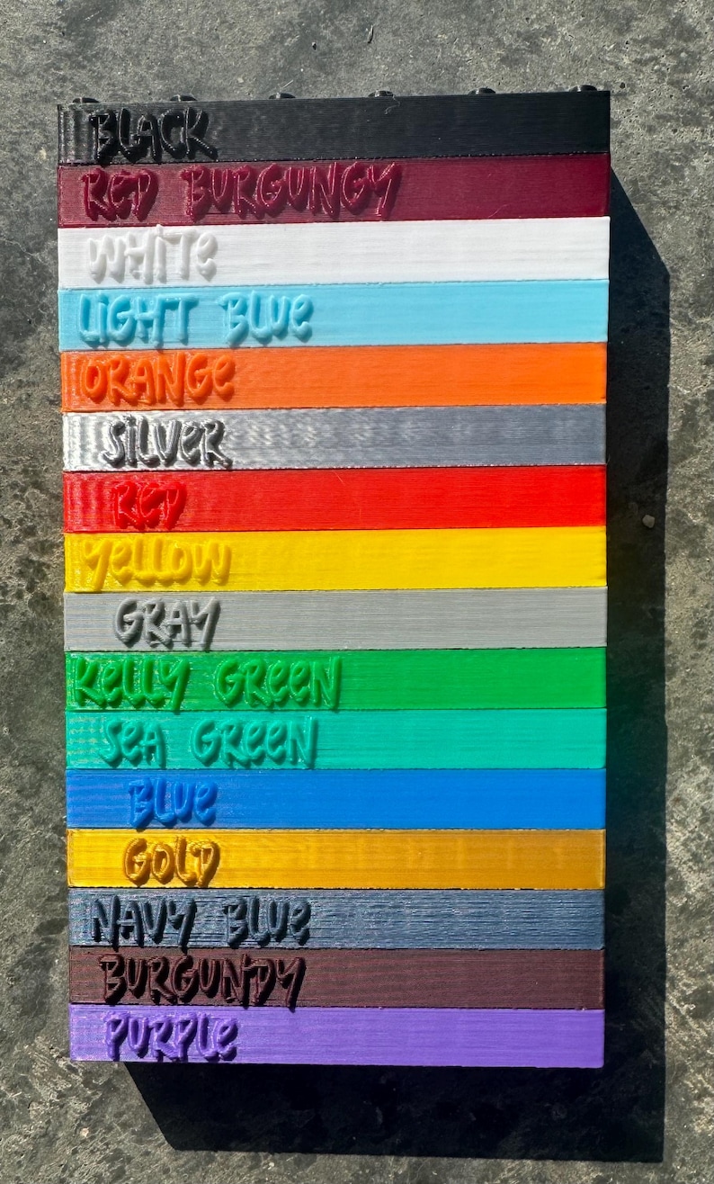 May include: A color chart with 15 different colors, including black, red burgundy, white, light blue, orange, silver, red, yellow, gray, kelly green, sea green, blue, gold, navy blue, burgundy, and purple.