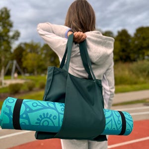Woman is ready for yoga with yoga mat and yoga bag.