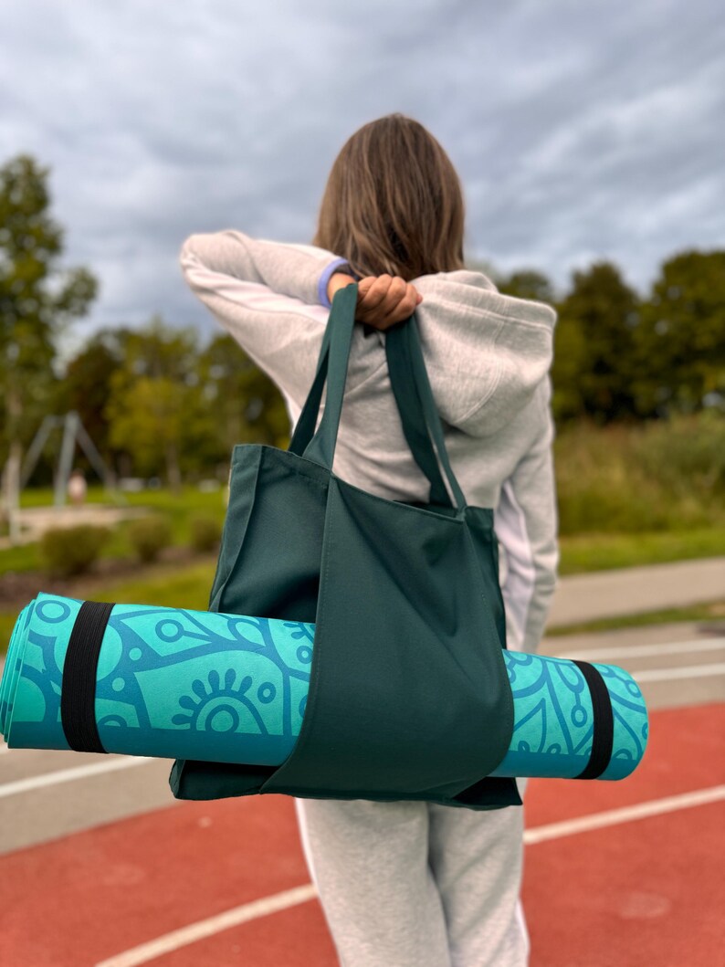 Woman is ready for yoga with yoga mat and yoga bag.