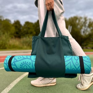 Going woman with dark green yoga bag.