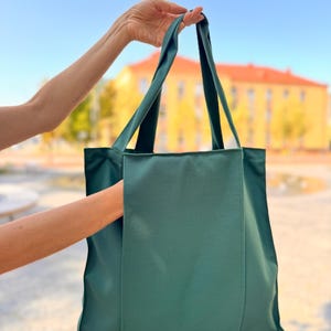 Forest green tote bag with external pocket.