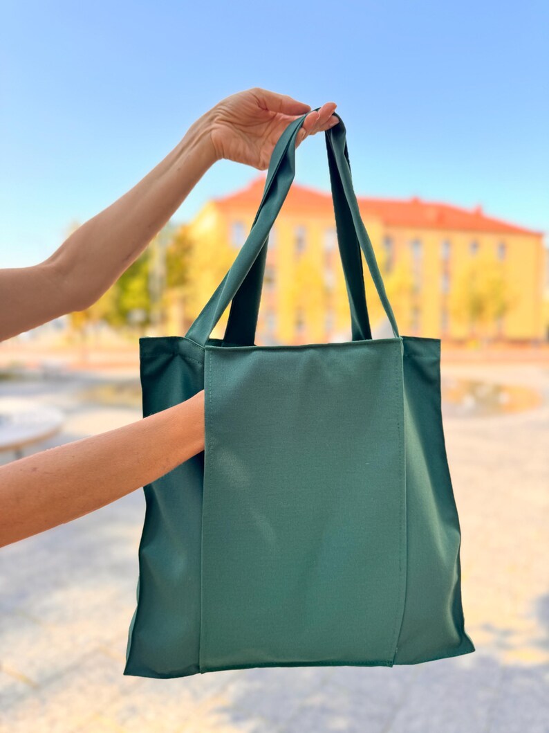 Forest green tote bag with external pocket.
