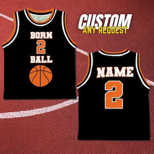 May include: Black basketball jersey with orange accents. The front of the jersey has the text "BORN 2 BALL" and a basketball graphic. The back of the jersey has the number "2" and the word "NAME".