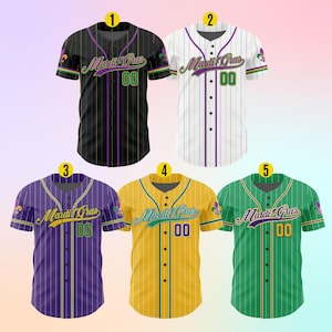 K&ouml;nnte beinhalten: F&uuml;nf Baseballtrikots mit Mardi Gras-Motiven. Die Trikots sind schwarz, wei&szlig;, lila, gelb und gr&uuml;n mit lila und goldenen Streifen. Jedes Trikot tr&auml;gt den Text "Mardi Gras" und die Nummer "00" auf der Vorderseite.