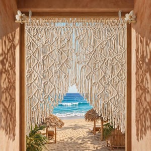 May include: Cream-colored macrame curtain with a leaf pattern, hanging in a wooden doorway. The curtain is suspended from a wooden rod with flower-shaped accents. The view through the curtain reveals a beach with huts and the ocean.