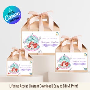 May include: A white ceramic mug with a black handle and the text "But First, Coffee" in a black, handwritten-style font. The mug is on a white surface.