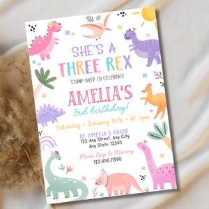 May include: A colorful invitation for Amelia's 3rd birthday, featuring dinosaur illustrations in pink, purple, and green. The text reads "She's a Three Rex" and includes party details: date, time, and location.