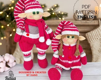 May include: Two handmade knitted dolls featuring festive red and white striped hats and clothing. The taller doll wears a scarf and overalls, while the shorter doll has braided hair and a buttoned coat. Text reads PDF PATTERN ENGLISH.