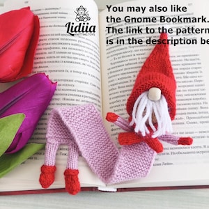May include: A knitted gnome bookmark with a red hat, white beard, and a long light purple body resting on an open book. Beside the book are red and purple tulip flowers. The text on the page reads: You may also like the Gnome Bookmark.