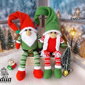 May include: Two handmade knitted elf dolls. One elf wears a red hat, green vest, and striped green and white legs. The other elf wears a green hat, red shirt, and striped red and white legs. The dolls are festive and whimsical.