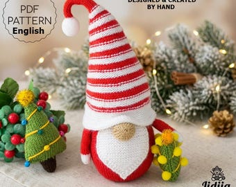 May include: A knitted gnome figurine with a tall red and white striped hat, a white beard, and a round tan nose. The gnome holds a small green knitted tree with yellow pom-poms. Text reads PDF PATTERN English and DESIGNED & CREATED BY HAND.