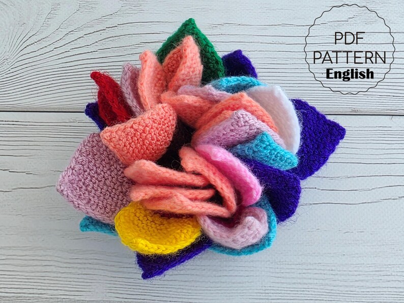 Brightly colored knitted flower mats folded together and stored inside a small handknit basket.