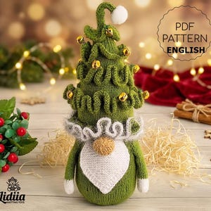 May include: A green knitted Christmas tree gnome with a white beard and collar, decorated with gold bells and a white pom-pom. The text "PDF PATTERN ENGLISH" is visible. A festive holiday decoration.