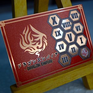 Op de afbeelding: Een rode en gouden Dragon Empire kaart met Japanse tekst en een drakenembleem. De kaart heeft Romeinse cijfers in gouden zeshoekige vormen. De kaart wordt gepresenteerd op een kleine houten ezel.