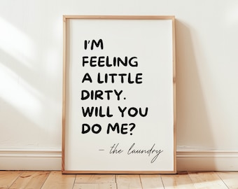 Op de afbeelding: Een ingelijst print met een witte achtergrond en zwarte tekst die "I'm feeling a little dirty. Will you do me? - the laundry" luidt.