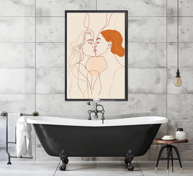 May include: A black and white line drawing of two people kissing. The drawing is framed and hanging on a white tiled wall above a black bathtub.