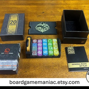 May include: A 20 Strong board game set including a black box, a Nemesis themed card, a black tray holding six colorful dice with various symbols, a Chip Theory Games deck box, and a General Rules of Play booklet with gold and black accents.