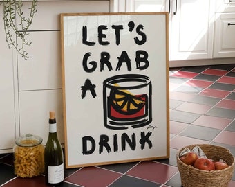 Puede incluir: Un letrero enmarcado con el texto "LET'S GRAB A DRINK" en letras negras, con una ilustración de un cóctel. Una botella de vino, un tarro de pasta y una cesta de manzanas están en primer plano. El suelo es de baldosas rojas y negras.
