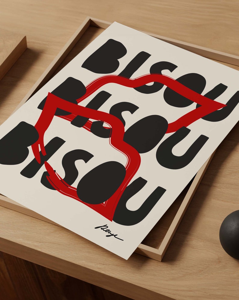 Op de afbeelding: Een zwart-witte print met het woord "Bisou" dat meerdere keren in een gestileerd lettertype wordt herhaald. Een rode hartvorm is om de woorden getekend.