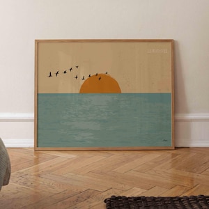 May include: A rectangular wall art print featuring a minimalist landscape with a muted beige sky, a large orange sun, and a textured teal sea. A flock of black birds flies across the horizon. The Japanese text 日本の夕日 is visible in the top right corner.
