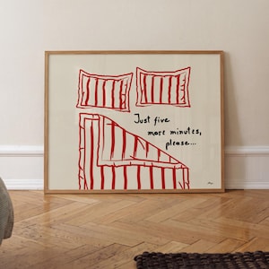 Könnte beinhalten: Ein gerahmter Kunstdruck mit einer Strichzeichnung in roter Tinte von zwei Kissen und einer gestreiften Decke auf cremefarbenem Hintergrund. Der Text "Just five more minutes, please..." steht in schwarzer Tinte in der Mitte.