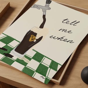 Puede incluir: Ilustraci&oacute;n de una pinta de cerveza oscura que se vierte de un grifo, con espuma. El vaso tiene un emblema de arpa dorada. Las palabras "tell me when" est&aacute;n escritas en cursiva. El fondo tiene un patr&oacute;n de cuadros verdes y blancos.
