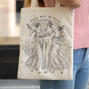 May include: A set of three ceramic mugs with a speckled, cream-colored glaze. Each mug features a different hand-painted design: a blue and green leaf, a yellow flower, and a red berry. The mugs have a simple, modern design.