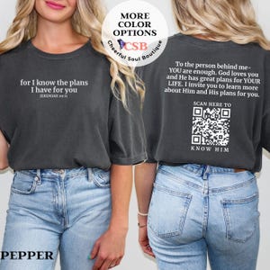May include: Pepper-colored t-shirt with white text on the front: "for I know the plans I have for you" and "JEREMIAH 29:11." The back has a message and a QR code that says "SCAN HERE TO KNOW HIM."