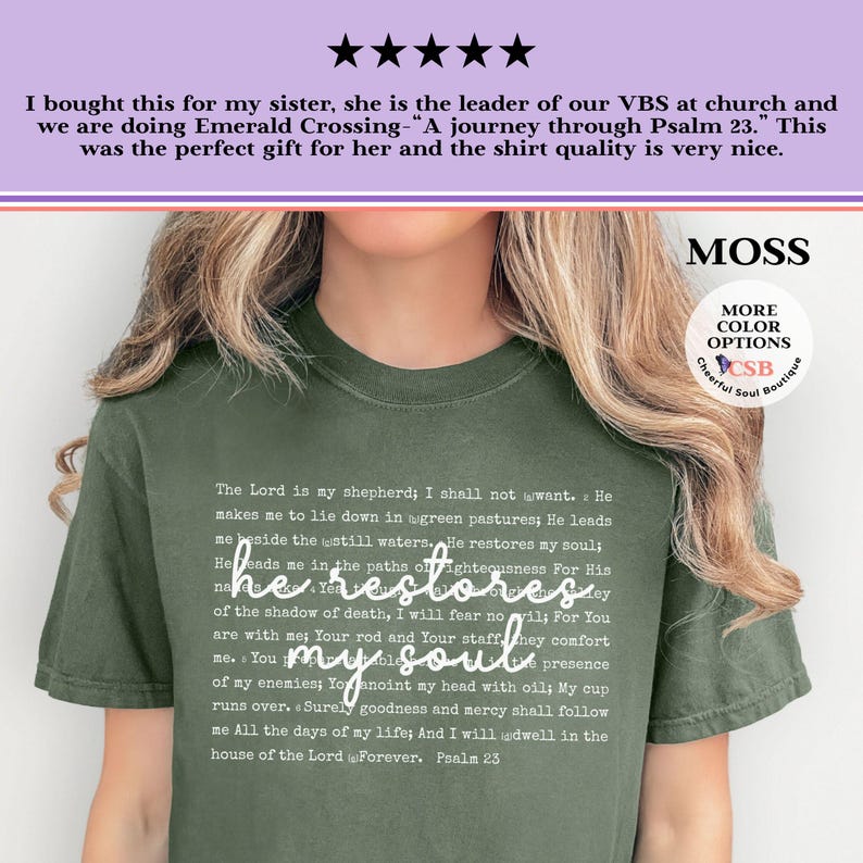 Puede incluir: Una camiseta de manga corta color verde musgo con el texto completo del Salmo 23 impreso en una fuente peque&ntilde;a y clara. La frase he restores my soul est&aacute; impresa en una letra cursiva blanca m&aacute;s grande en el centro del pecho.