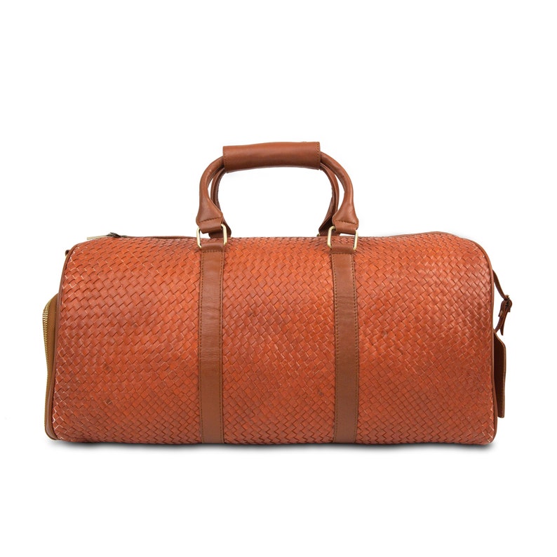 May include: A brown leather woven duffel bag with two top handles and a zipper closure.