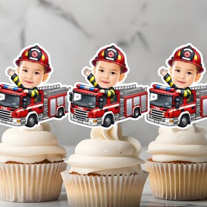 Könnte beinhalten: Drei rote Feuerwehrwagen-Cupcake-Topper mit einem Cartoon-Feuerwehrmann-Gesicht auf jedem. Die Topper sind auf weißem Karton gedruckt und bereit, auf Cupcakes gelegt zu werden.