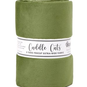 May include: A roll of olive green Cuddle Cuts fabric. The fabric is extra-wide and precut to 3 yards. The fabric is wrapped with a white label that has the words "Cuddle Cuts" printed on it.