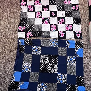 May include: Two patchwork quilts. The top quilt features squares of white with pink roses, black with white polka dots, and black squares. The bottom quilt has squares of navy blue, black with white polka dots, and black and white floral patterns.